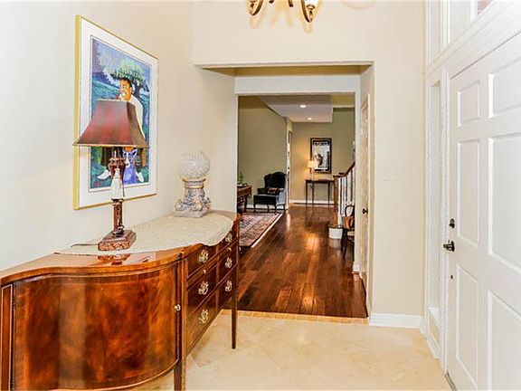 Two story foyer with travertine flooring beckons you to explore the treasures within.