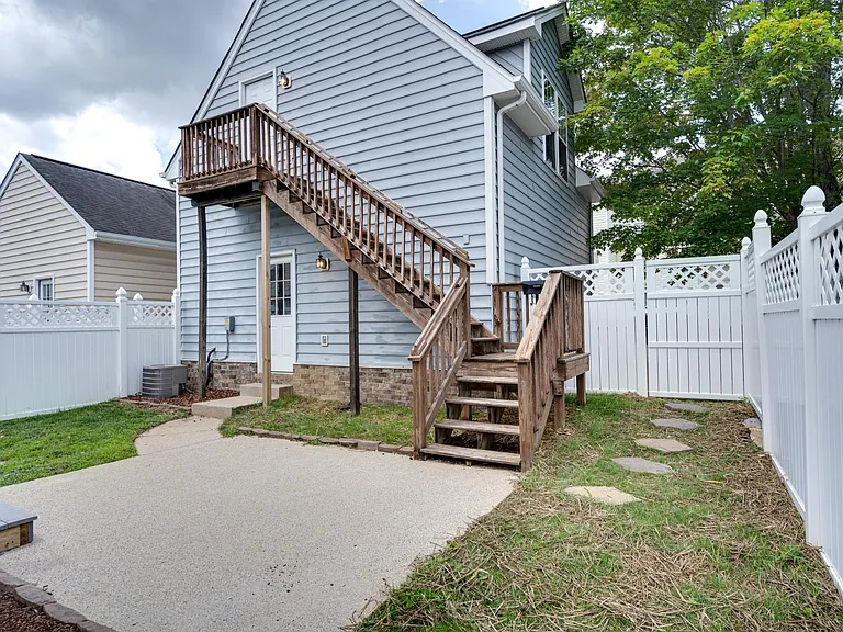 Fenced-in porch, stairs leading up to garage apartment