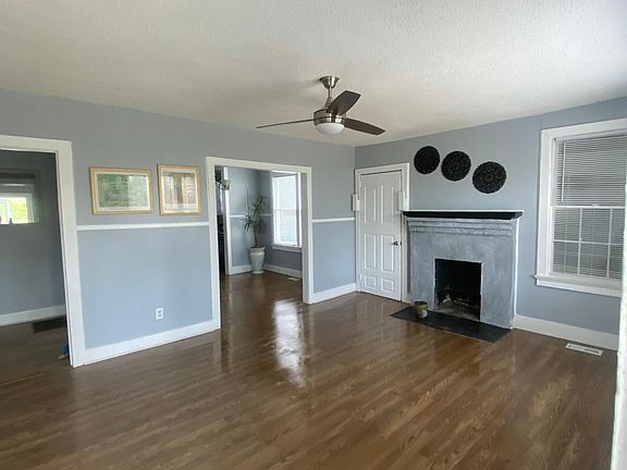 Living room with hardwood floors, fireplace and ceiling fans
