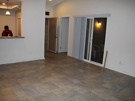 Living room view showing breakfast bar, entry, laundry room to the right, sliding door to patio.