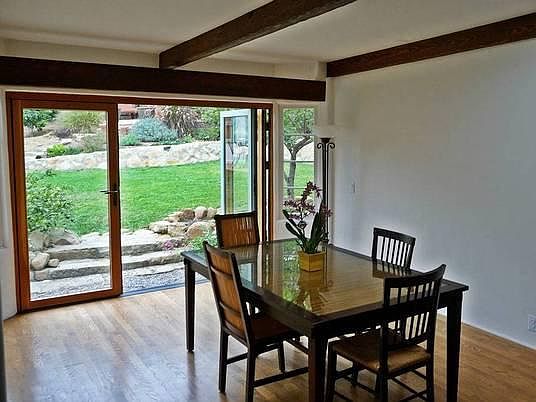 Dining room with Nano custom doors that open to backyard sea