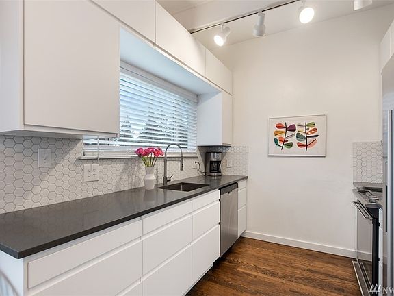 Clean, crisp new white cabinets, quartz counters and perfectly matched back splash tile!