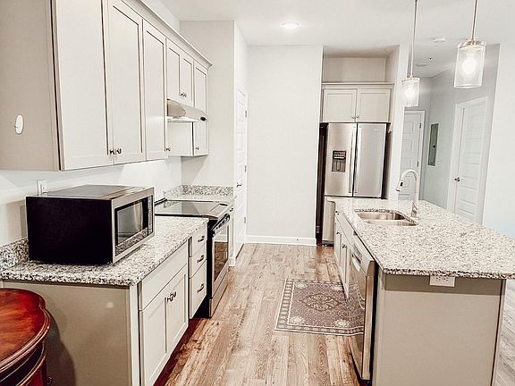 Kitchen (alternate view). Includes dishwasher, refrigerator, oven/stove, and microwave.