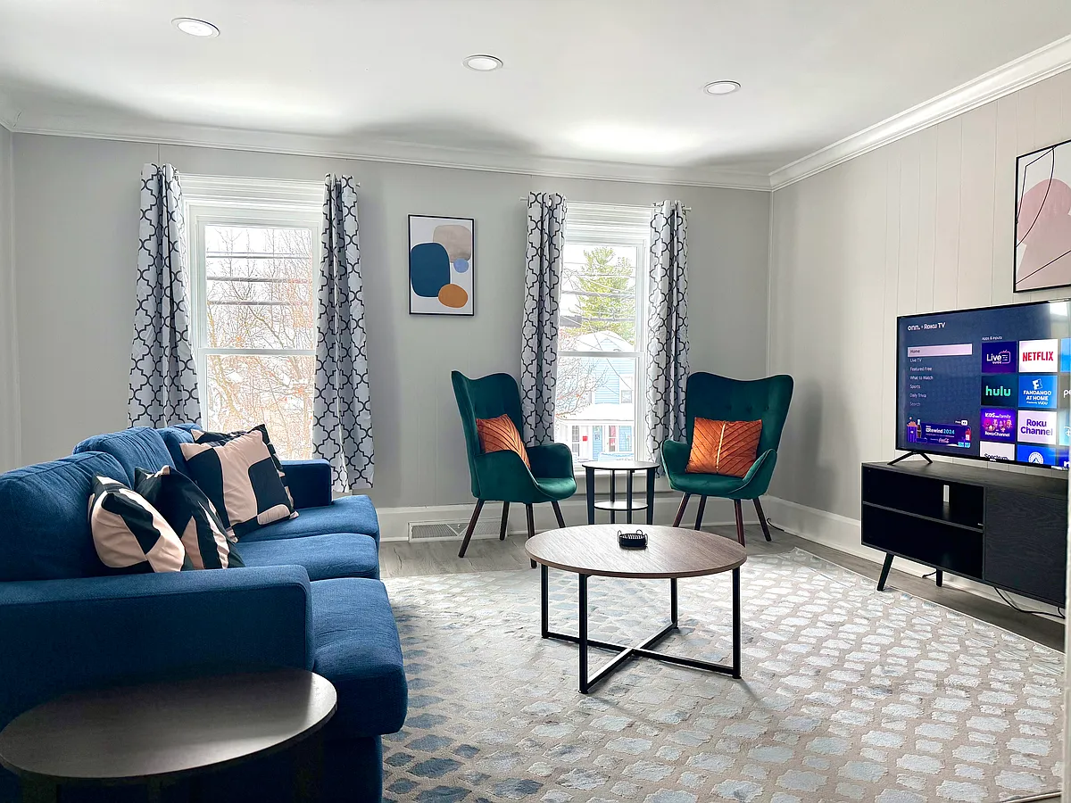 Relax in this cozy and stylish living room featuring a deep, large comfortable sofa & two chic accent chairs, perfect for sipping coffee & reading while enjoying the view through the window. A good-sized smart TV is also available for your entertainment. - 426 Coffeen St #2