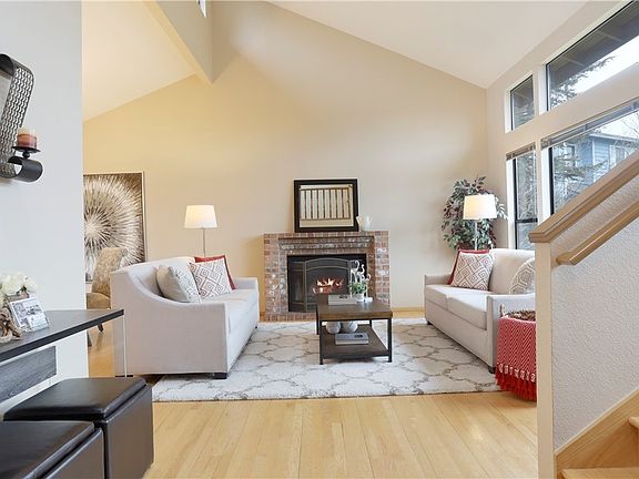 The formal living room with vaulted ceiling and clerestory windows is comfortable and inviting. The room features an abundance of windows for natural lighting, original hardwood floors and wood-burning fireplace. A great space to relax and unwind.