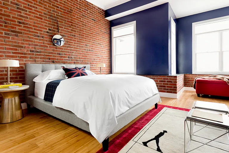 Master suite with queen bed and leather sofa, walk-in closet, exposed brick wall, 4 windows and skylights!