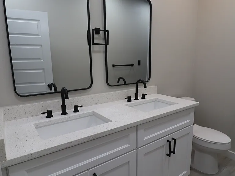 Bright and stylish secondary bathroom with dual sinks, contemporary finishes, and generous counter space.