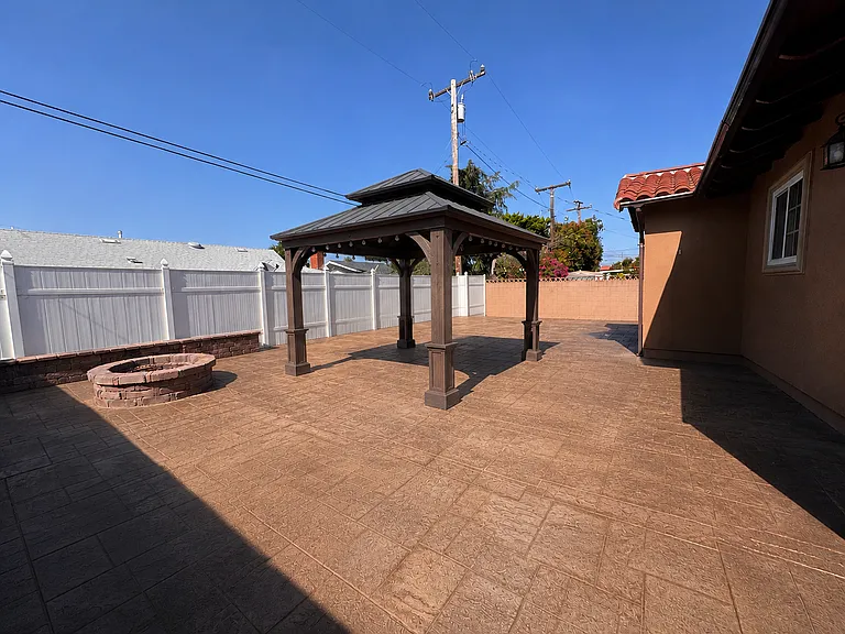 The private backyard features a built-in fire pit and a lighted gazebo, creating the perfect space for outdoor entertaining and relaxation.