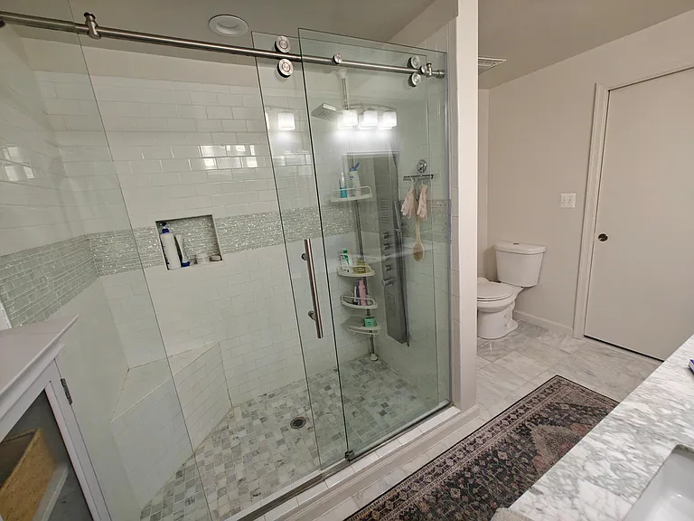Marble tile shower, pocket door to bathroom.