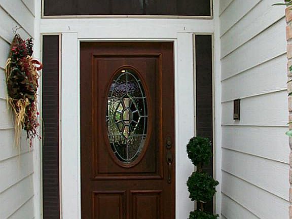COVERED ENTRY WITH BEVELED GLASS DOOR, & SOLAR SCREENS