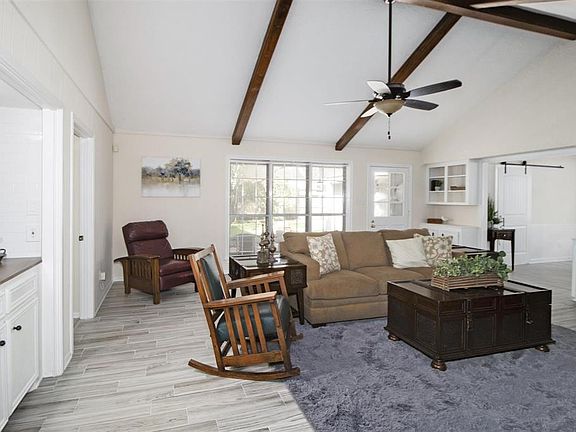 Living room has vaulted ceilings, wet bar and built-in shelving