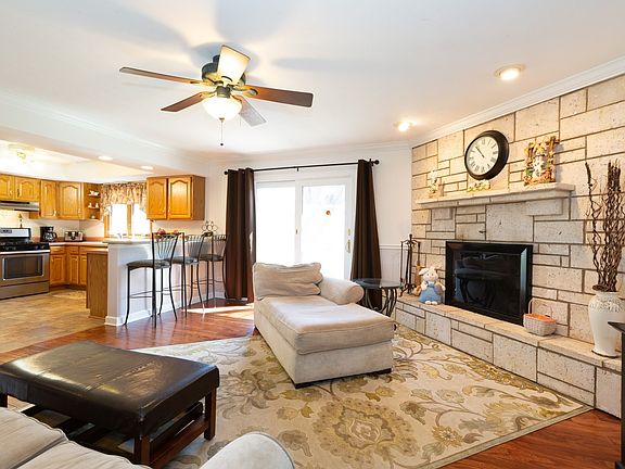 Family Room flows with the Kitchen. Great for entertaining. Features a Fireplace, wood laminate flooring and Patio doors that lead to the large fenced back yard.