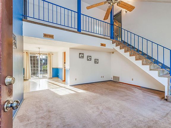 Living room with vaulted ceilings and ceiling fan.