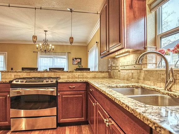 New open bright kitchen with gas stove. New dishwasher. Opens to porch and patio.