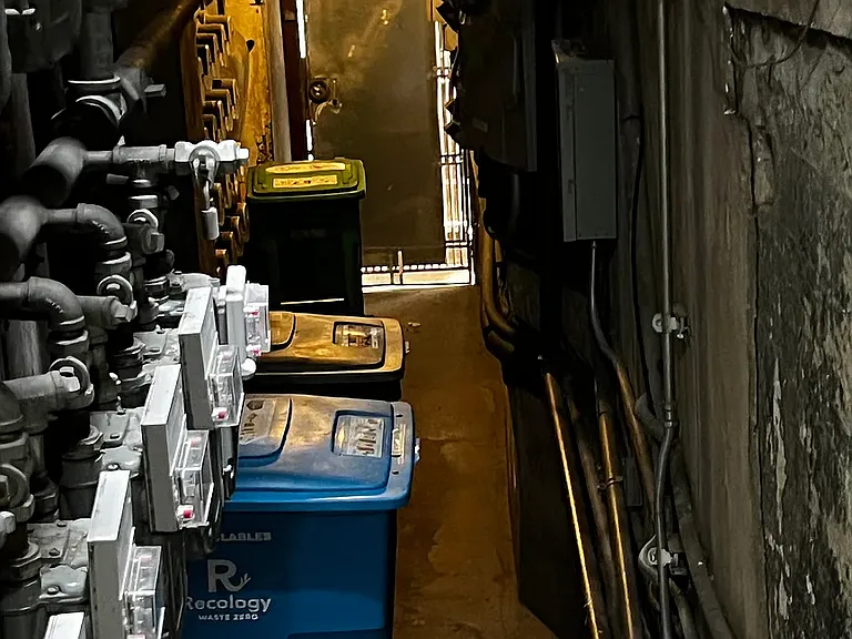 Trash and recycling is located at the landing on the way to the laundry.