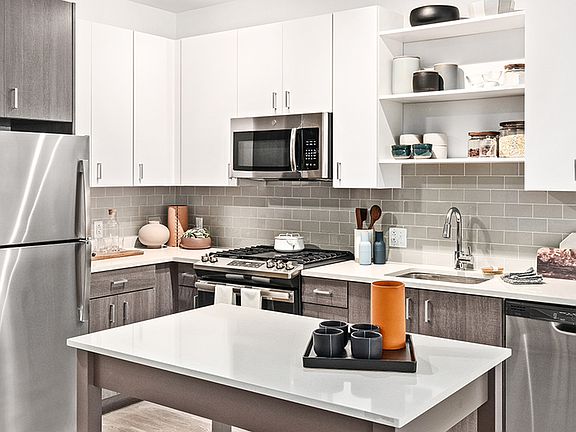 Beautifully equipped kitchens with stunning white cabinetry with chrome pulls and stainless steel appliances