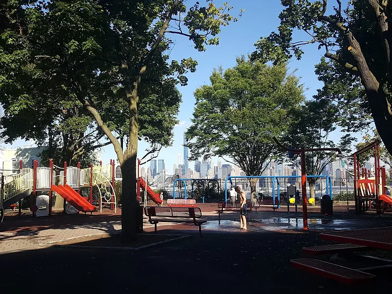 Gregory Park with Manhattan skyline at the end of the block