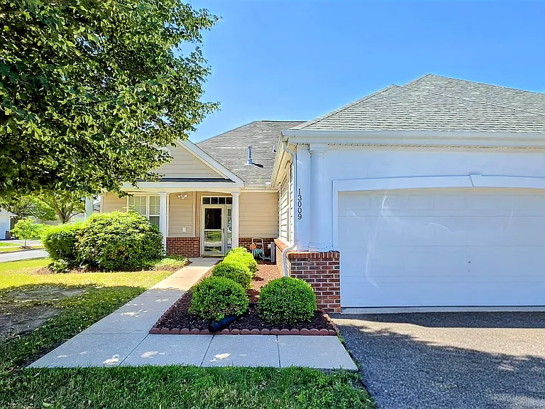 Stunning house featuring a manicured front lawn, immaculate landscaping, and an attached garage.