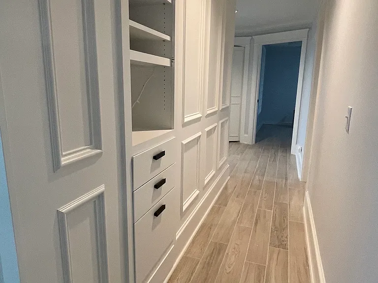 Hallway from living room to guest rooms and family room/large office. Built in bar or stereo setup.
