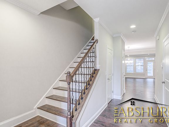 Front entry foyer featuring engineered hardwood flooring, oak tread staircase and wrought iron