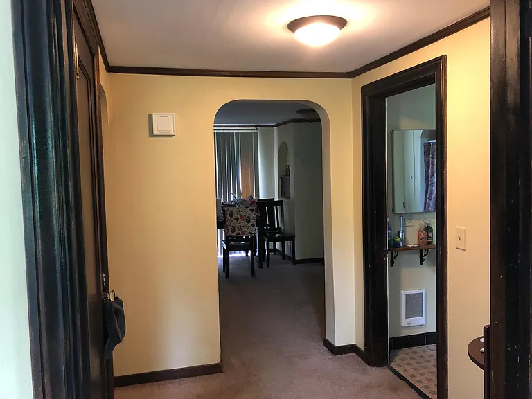 Hallway from the living room leads to bathroom (on the right) bedroom (on the left) and dining room straight through (on the left of dining room is another hall which leads to bedroom; to the right of the dining room leads to kitchen)