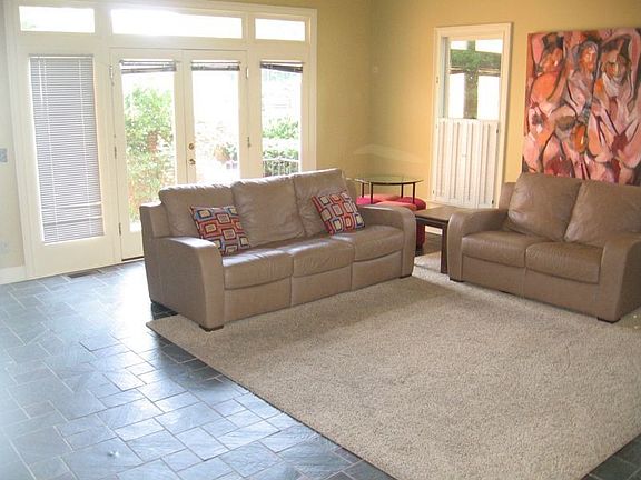 Den with built-in bookshelves and fireplace.  Doors leading to courtyard 