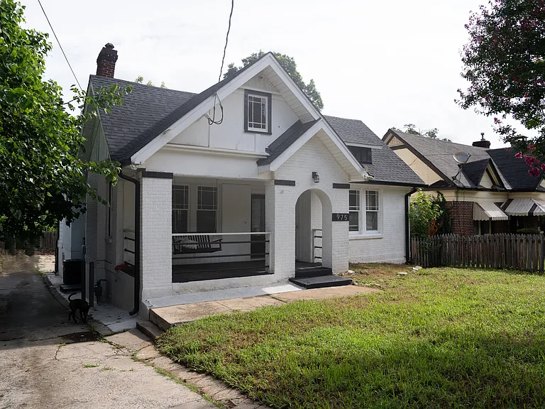 Spacious front yard and driveway leading to the backyard