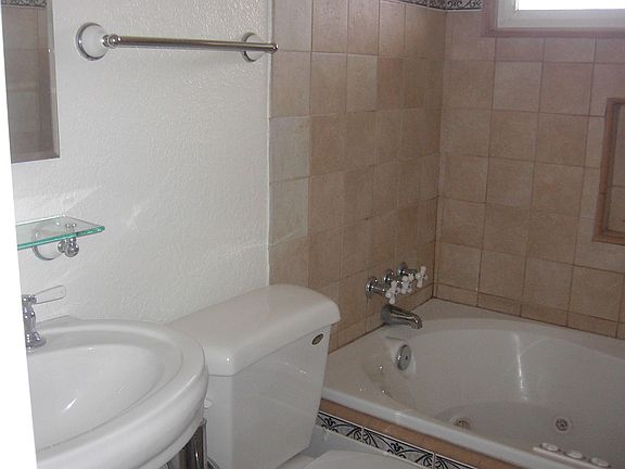Beautiful remodeled bath with jetted spa tub & pedestal sink.