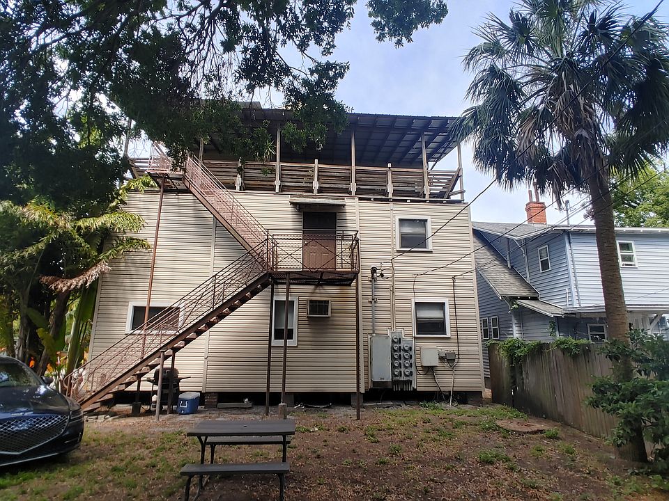 View of Building Rear and shared outdoor space with picnic table and grill.