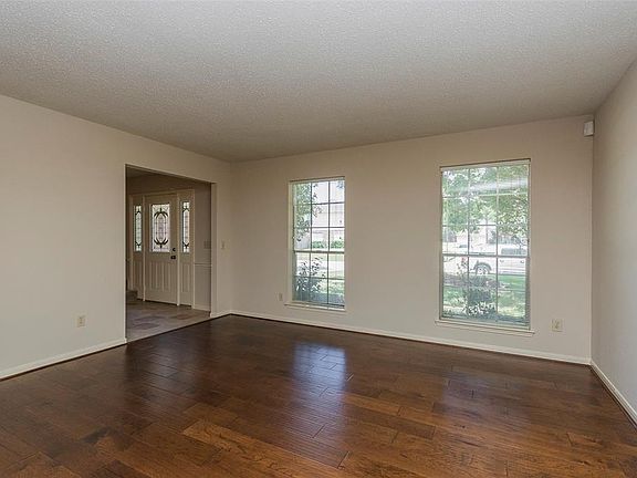 The large living room to the left of the front foyer has been updated with beautiful wood flooring.