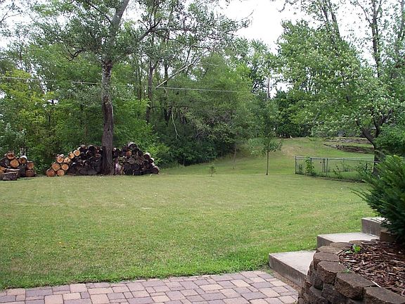 Generous rear yard features a ring of trees and firepit.