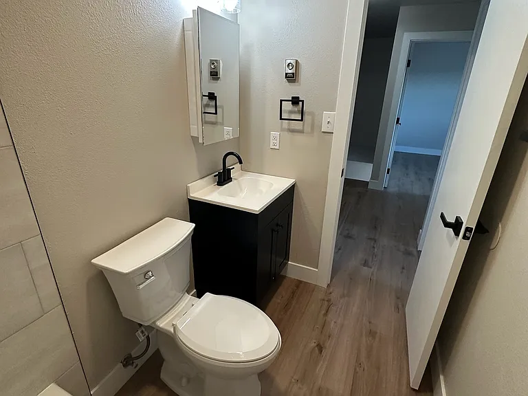 Beautiful and brand new full bath. Primary bedroom in the far doorway.
