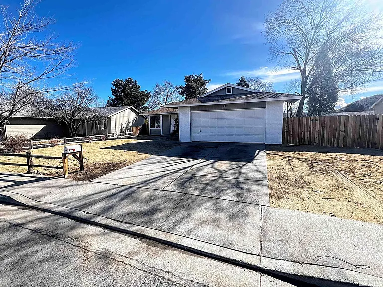 Street view of driveway and two stall garage