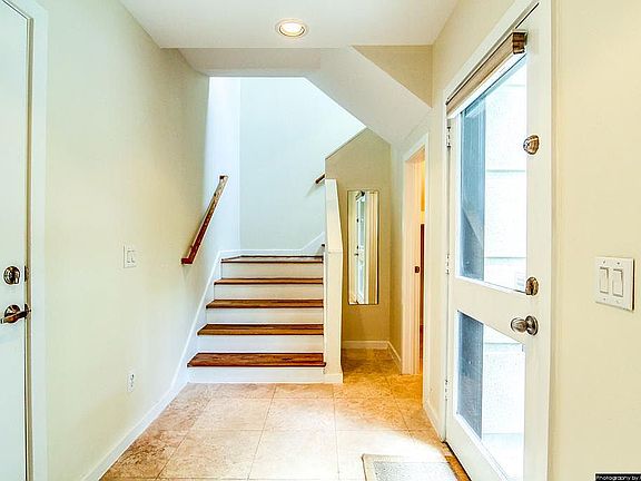 Elegant foyer w/travertine floors & glass door.