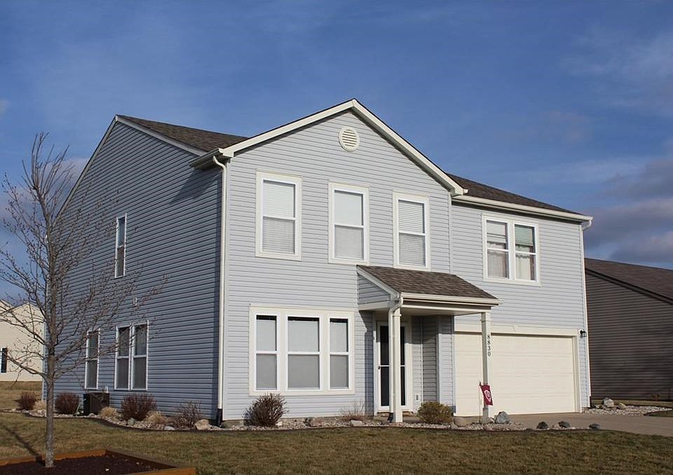 Corner landscaped lot with continuous concrete edging.