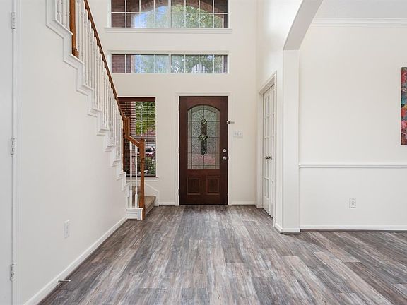 Grand 2-story foyer with a glimpse of the formal dining room and study on the right. Recent hi-end laminate flooring in all main areas.