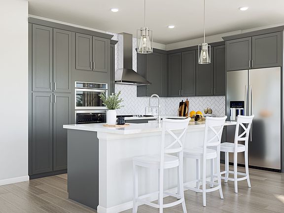 A modern, well-designed kitchen with gray cabinets, white countertops, and a central island with bar