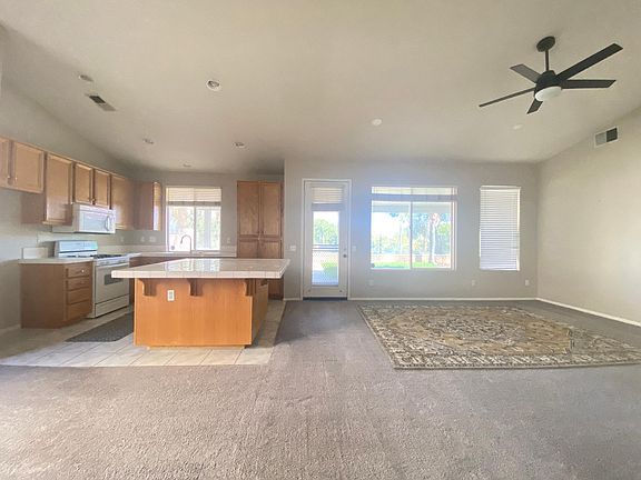 Kitchen and dining area to left, living room to right. 8' x 10' area rug shown for scale of room