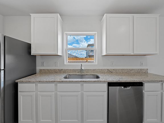 Stainless steel appliances and granite countertops are found in the kitchen