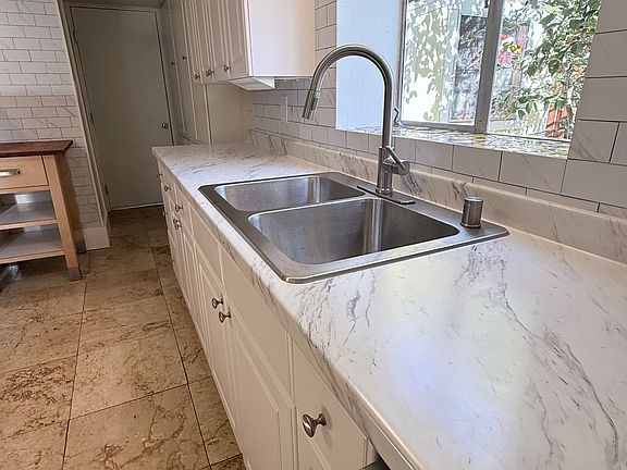 Updated kitchen countertop, sink, lighting and stainless steel appliances