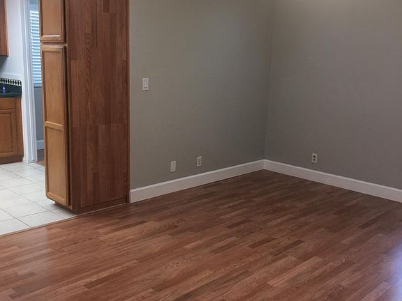Family room that is open to the kitchen area with ceiling fan