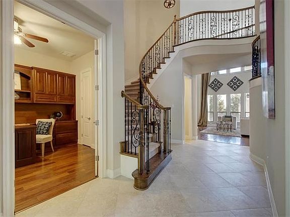 The grand foyer has a sweeping staircase. You can see the dedicated study entry from here.