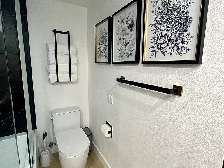 Remodeled bathroom with tub shower and closet, double sink