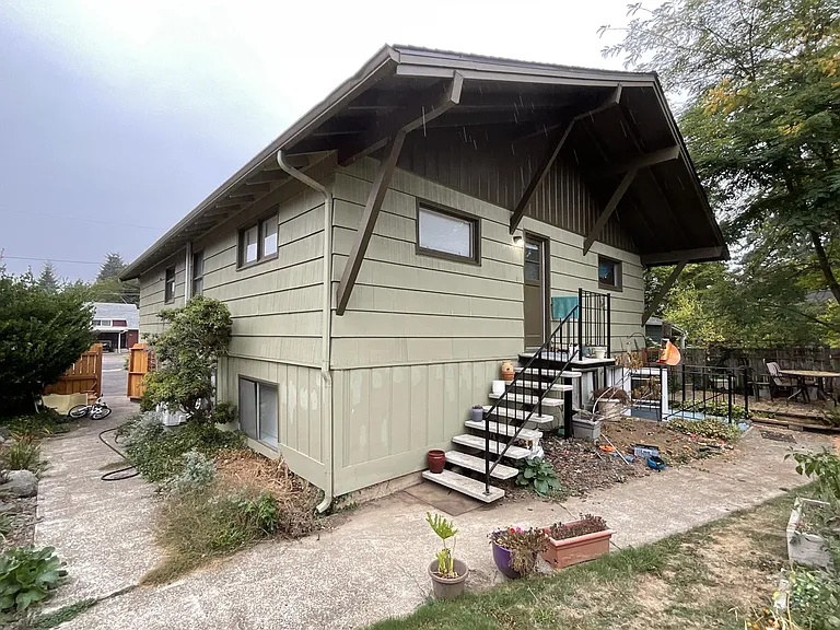 Back view of property with back entrance of upstairs unit and view of shared backyard