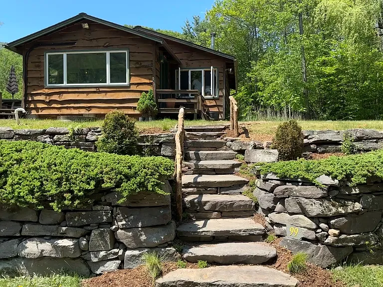 Stone stairs leading to Grandview Cabin with its live edge siding and large picture window.
