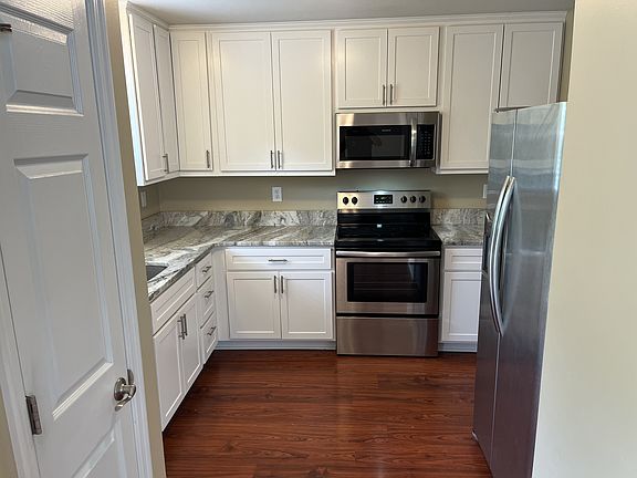 Upgraded kitchen with granite counters, stainless appliances, 42" cabinets, and pantry for extra storage.