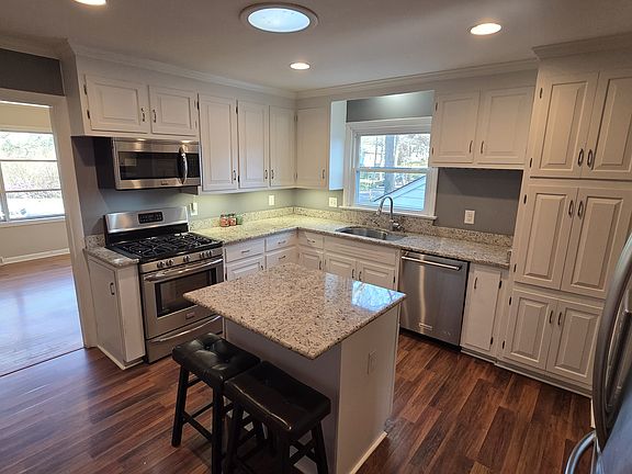 Kitchen with granite countertops, convection gas range, dishwasher, refrigerator and microwave