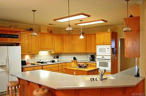 The kitchen features solid surface counters, ample cabinetry and