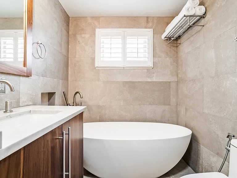 Beautiful floor to ceiling limestone and custom walnut vanity. Plus Large freestanding tub