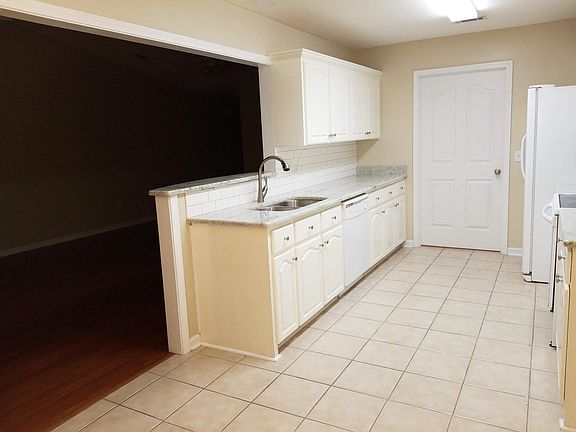 Stove and fridge are on the right. Door leads to the garage and indoor laundry, pantry